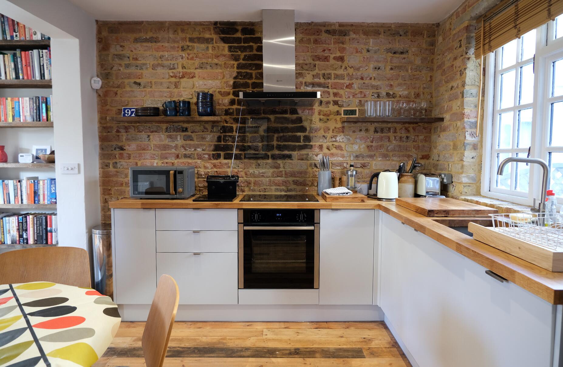 White kitchen against exposed brick